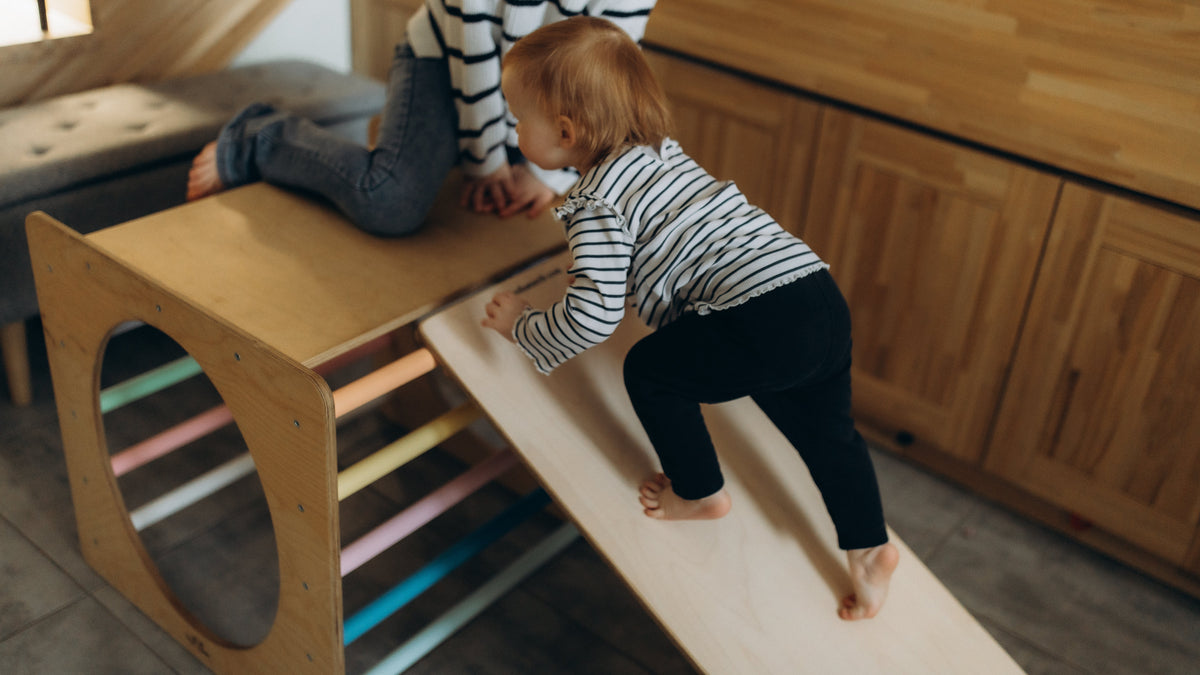 Child climbing on wooden cube toy