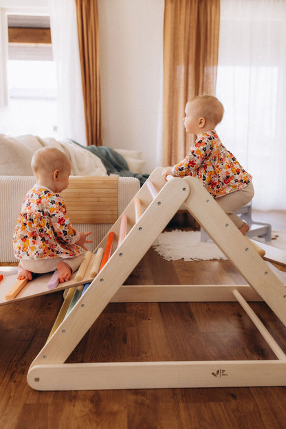 Toddler climbing on wooden climbing triangle