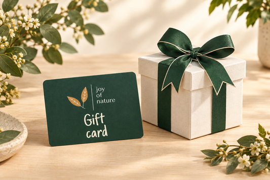 Joy of Nature gift card and wrapped present on a natural background